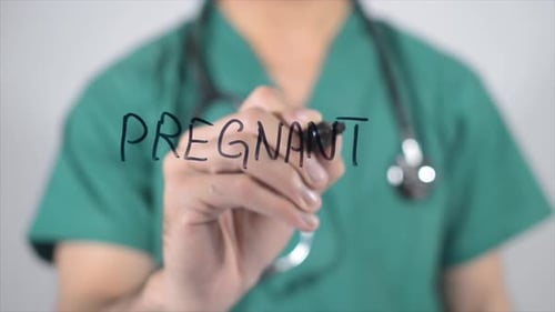 Medical Professional Writes Pregnant on Glass Surface