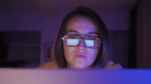 Nahaufnahme einer müden Frau, die nachts am Laptop arbeitet, Mädchen mit Brille und Reflexionen, die überlastet sind