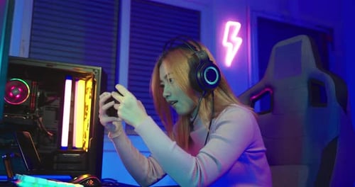 Excited Woman Gamer Playing on Mobile Phone