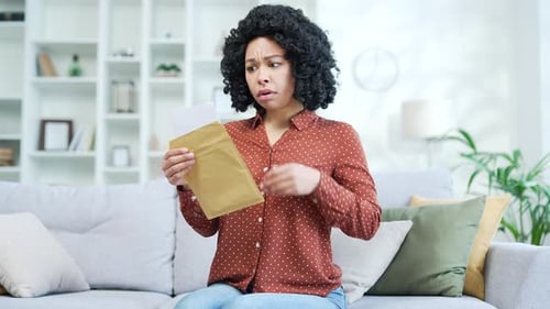 Woman Reading Letter With Shocking News Indoors