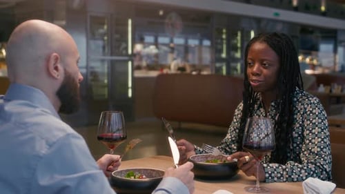 Couple bi-ethnique ayant un dîner romantique au restaurant