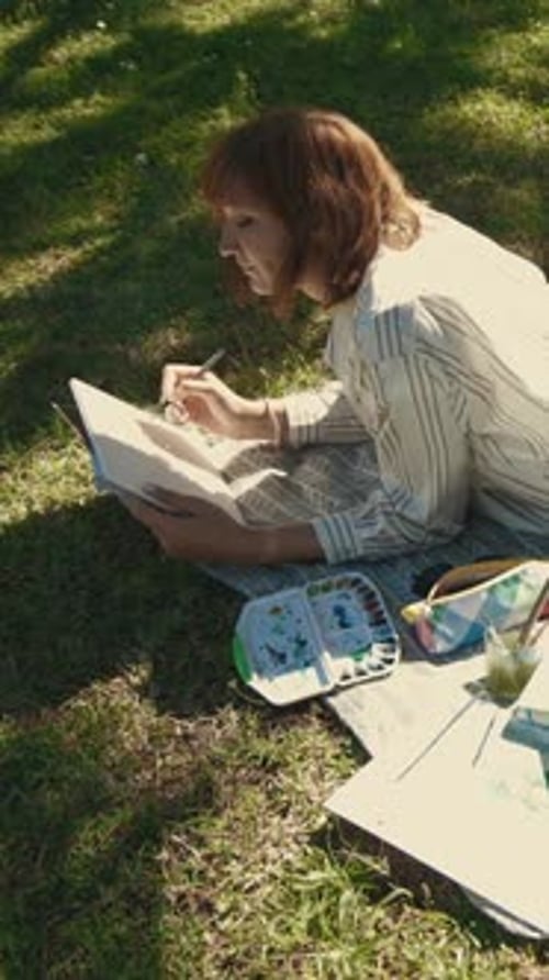 Woman Creates Artwork in a Sunny Green Field