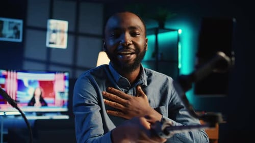 Man records video broadcast in dark studio at night