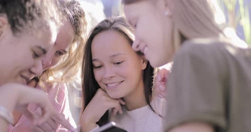 Gruppe von Freundinnen, die Bilder aus sozialen Medien auf dem Smartphone teilen