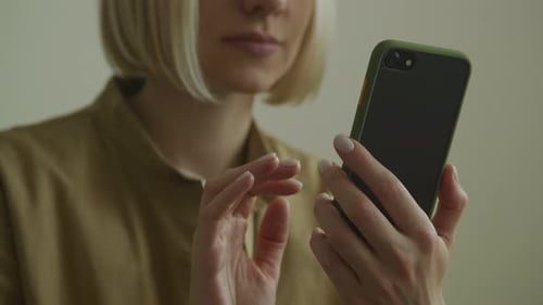 Unrecognizable Woman Browsing on Smartphone Indoors