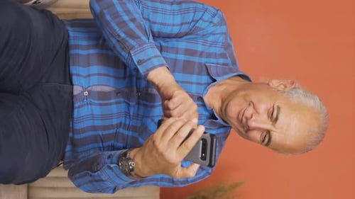 Senior Man Using Smartphone While Sitting on Couch