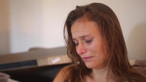 A close up portrait shot of a young woman with wounds and bruises, stares with a blank look and star