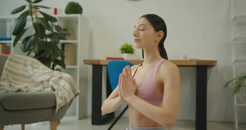 Woman Meditating and Practicing Yoga in Bright Room