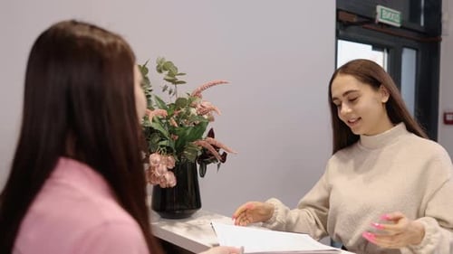 Woman Signs Form at Elegant Reception Desk