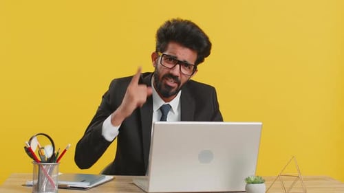 Man In Suit Gesturing at Desk