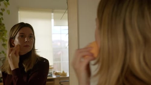 Woman Applying Makeup With Sponge in Home