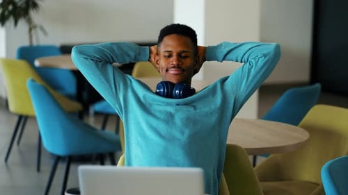 Young Adult Working on Laptop, Stretching Inside