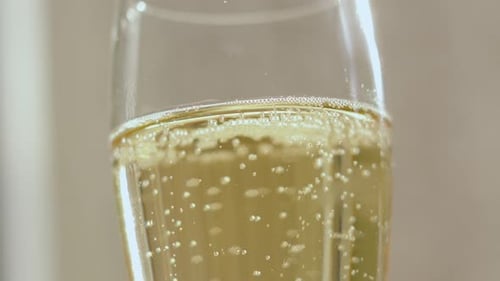 Tilted Angle of a Glass Flute Champagne French Sparkling Wine with Dozens of Bubbles Rising
