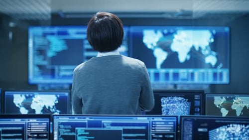 Na sala de controle do sistema, o operador técnico fica de pé e monitora várias atividades exibidas no Mul