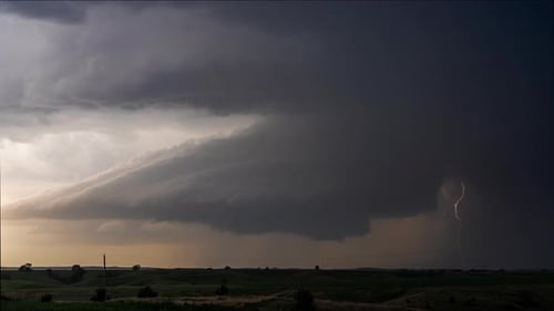 Ominous Storm Clouds over Rolling Green Field