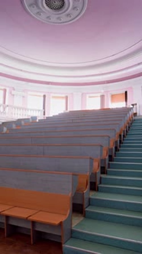 Beautiful conference hall with empty seats. Modern auditorium with wooden desks for lectures.