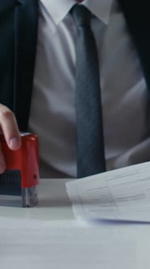 Hand Stamps 'Rejected' on Official Document