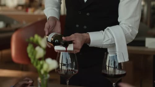 Unrecognizable Sommelier Pouring Red Wine in Luxury Restaurant