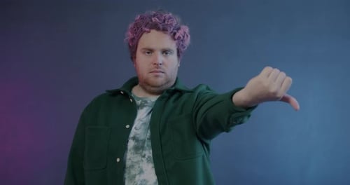 Portrait of Creative Guy Changing Thumbsup to Thumbsdown Hand Gesture Feeling Disappointed on Purple