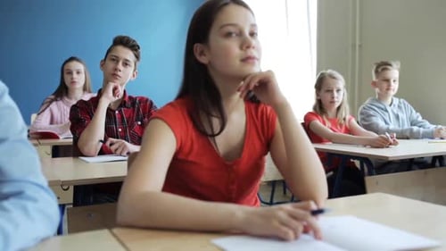 Students in a Classroom Taking Notes and Listening