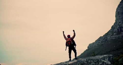 Man, hiker and fist pump with backpack on mountain cliff for achievement
