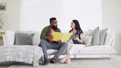 Divers amis féminins et masculins discutant, tenant des dossiers, travaillant à la maison, Ralenti