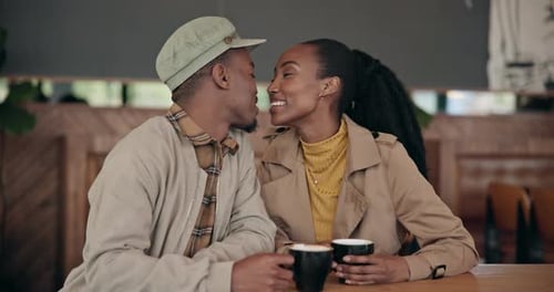 Couple, love and kiss with coffee at cafe, restaurant or diner for bond, care or romance
