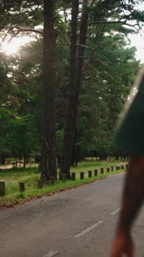 Young Male Tourist Walking Away From the Camera on a Paved Path Inside San Juan Monastery at Sunset