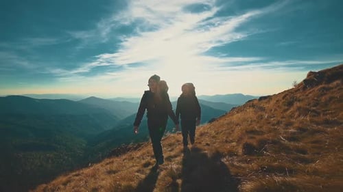 The couple walking along the evening mountain
