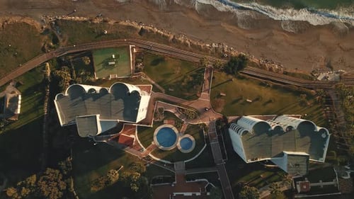 Top down view of apartment resort near the shoreline moving into the sea