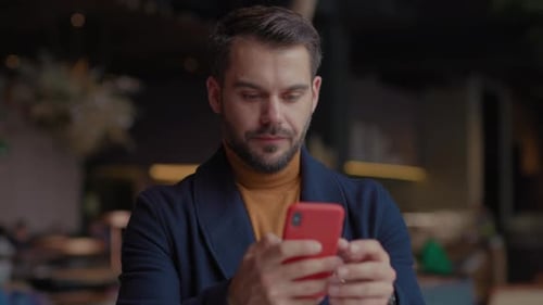 De cerca, un joven sonriente en un centro comercial usa un teléfono inteligente que escribe íconos de redes sociales con me gusta