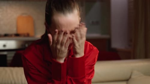 Woman Crying, Rubbing Eyes in Home