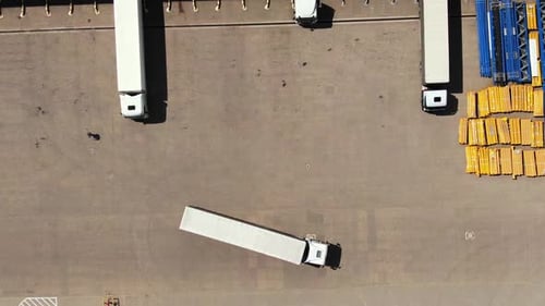 Top Down Aerial View of Semi Truck Maneuvering at Warehouse
