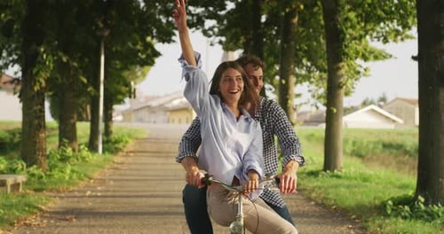 Romantic Couple Riding Bicycle on Rural Tree-Lined Path