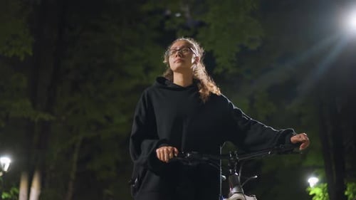 Woman with Bike in City Park at Night