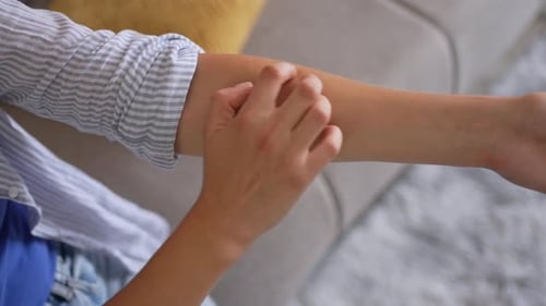 Woman scratching her itchy forearm skin