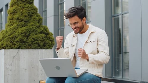 Happy Indian Man Working on Laptop Celebrate Success Win Money Get Online Good News Outdoors Street