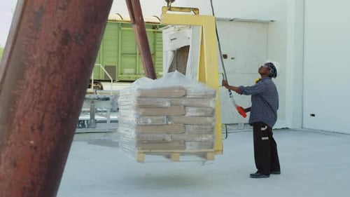 Female Plant Worker Lifting Marble Slabs on Crane