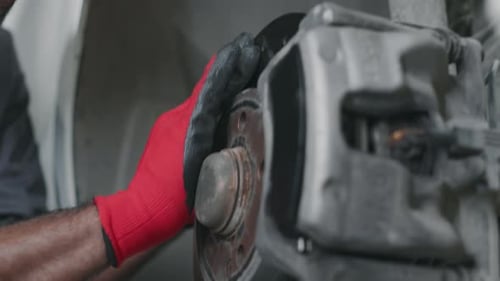 Hands of Unrecognizable Car Mechanic Checking Wheel Drum and Brakes