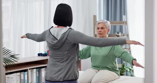 Senior Woman Doing Arm Stretches With Trainer