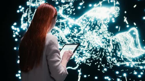 Woman Analyzing Data on Tablet with Light Graphics