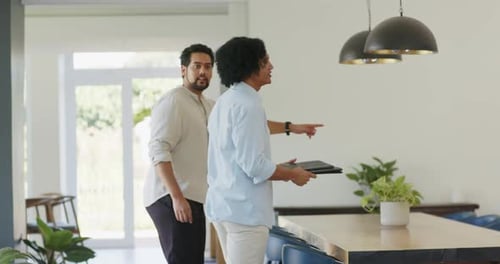 African American guides entering dining area leading tour pointing at pendant lights showing layout
