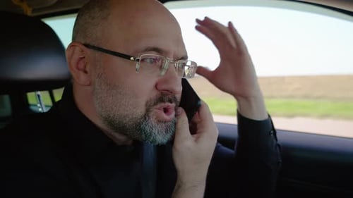 Man Talking on Phone While Driving Car