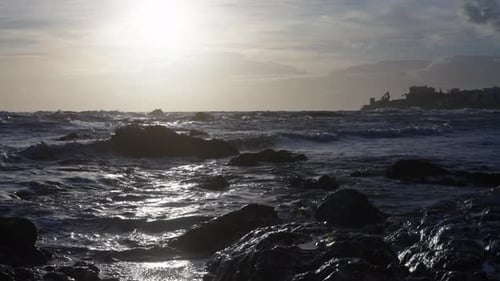 Sun shining over the rocky beach in slow motion