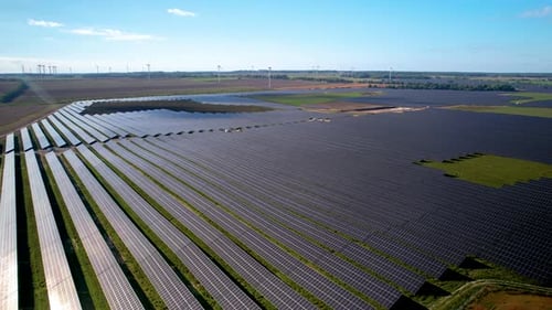 Aerial view of big sustainable electric power plant with many rows of solar photovoltaic panels for