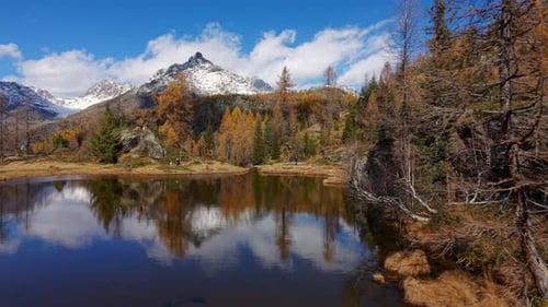 Vista aérea del lago montañoso Valmalenco Mufule con alerces otoñales y picos nevados