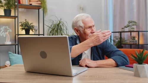 Mature Man Video Chatting at Home With Laptop