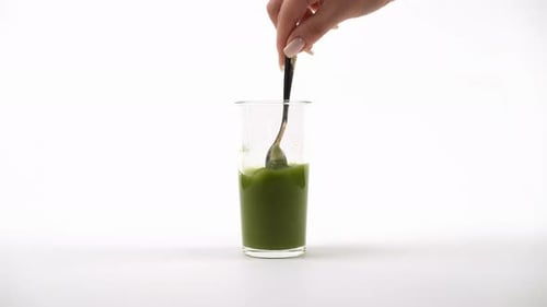 Einen lebendigen grünen Smoothie mit einer Gabel umrühren