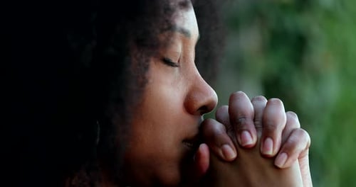 Contemplative Woman with Hands Together in Outdoor Setting