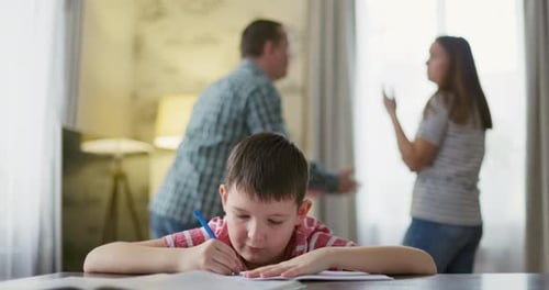 Un hijo se siente frustrado mientras sus padres se pelean en segundo plano